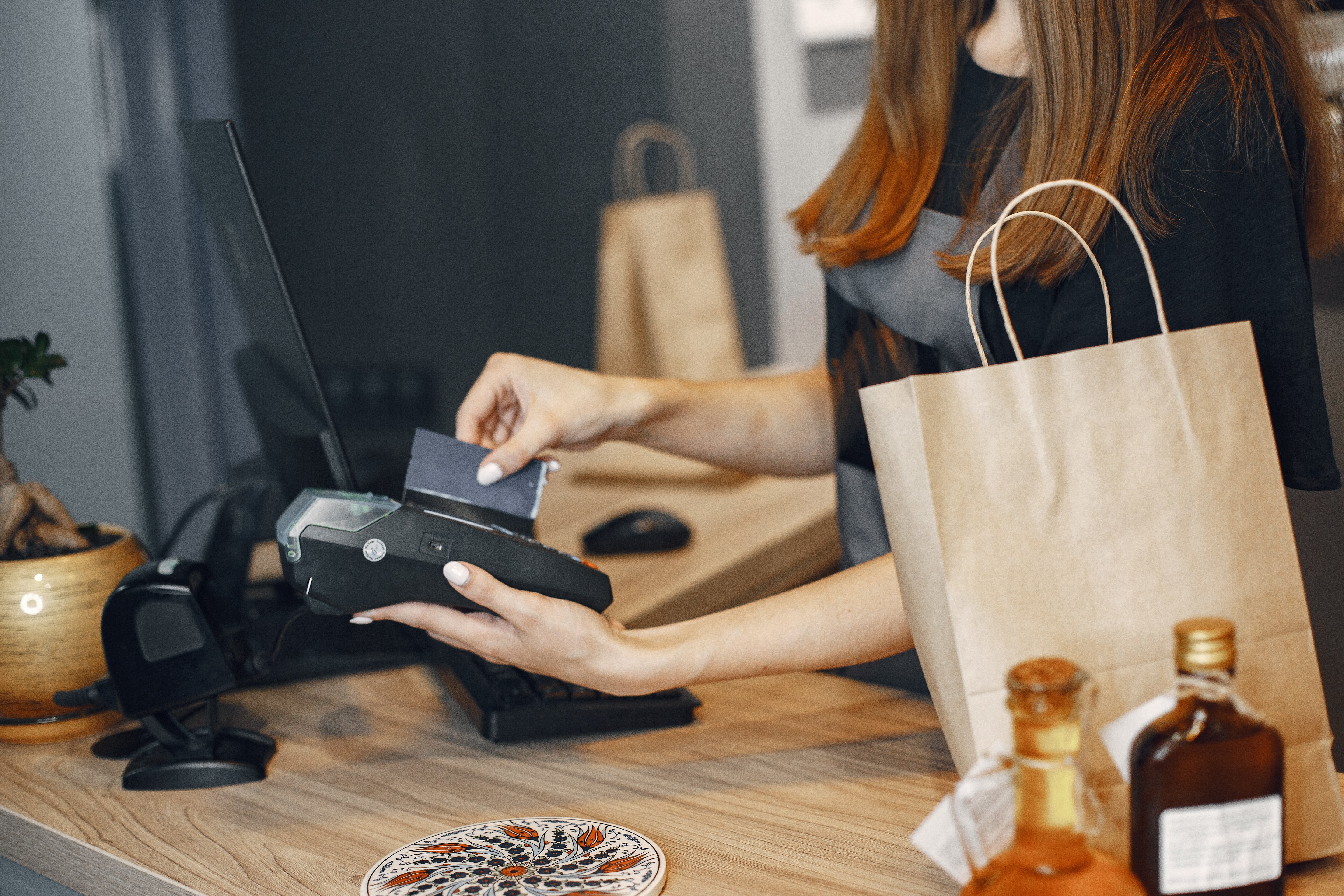 Woman operating a card terminal in a retail shop
