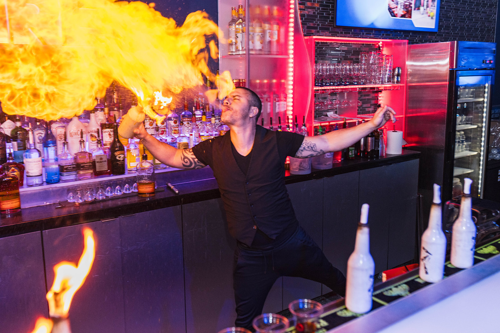man blowing fire tricks at bar